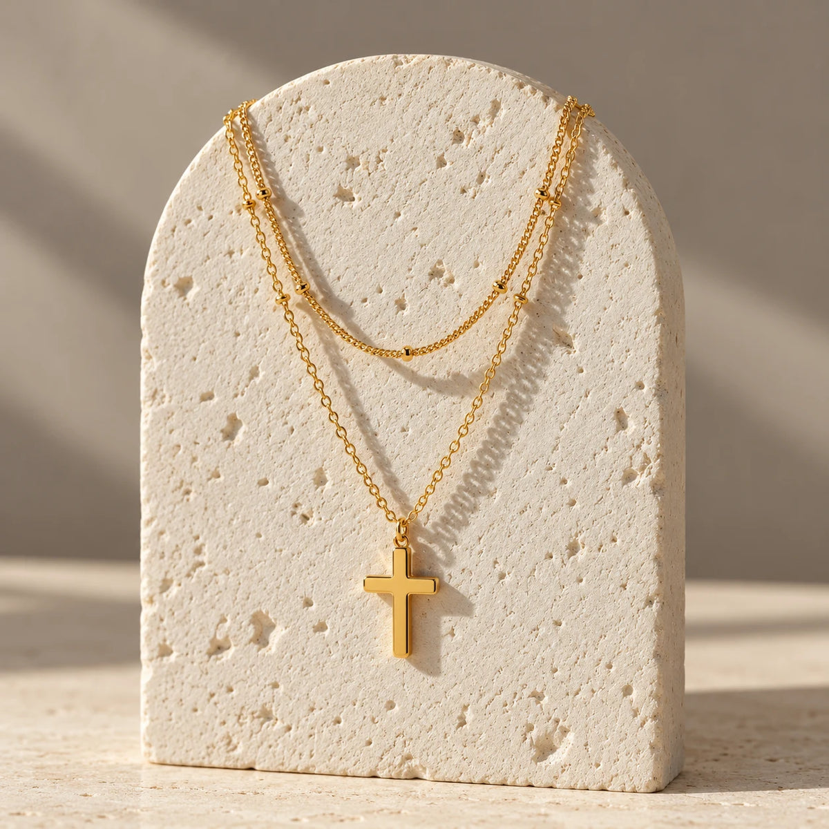14K gold plated Faithbound Layered Cross Necklace styled in a luxury still life