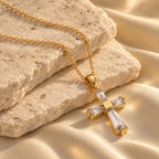 Haven Cross Necklace arranged on limestone and champagne silk