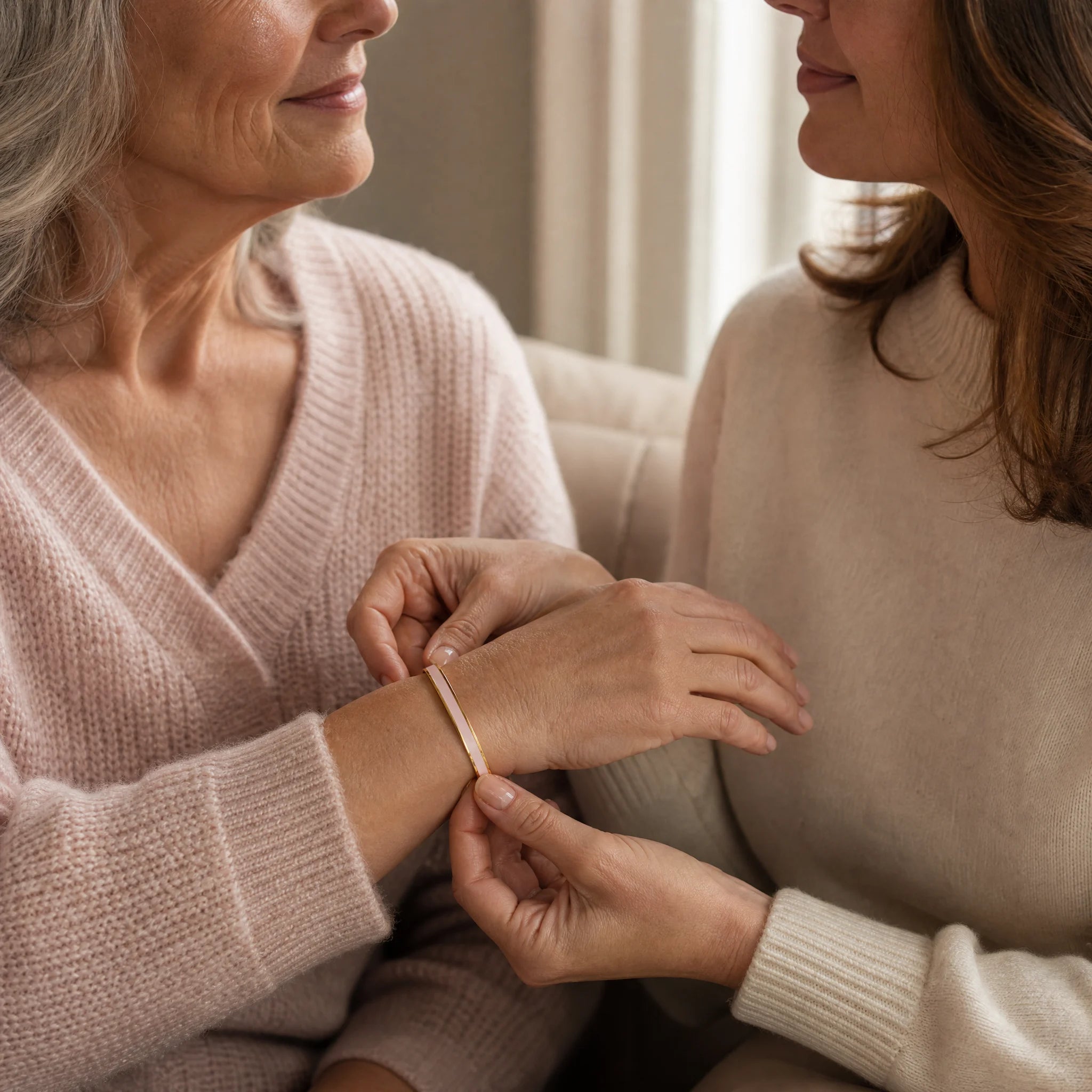 A woman gifting a blush enamel reminder cuff to someone she loves