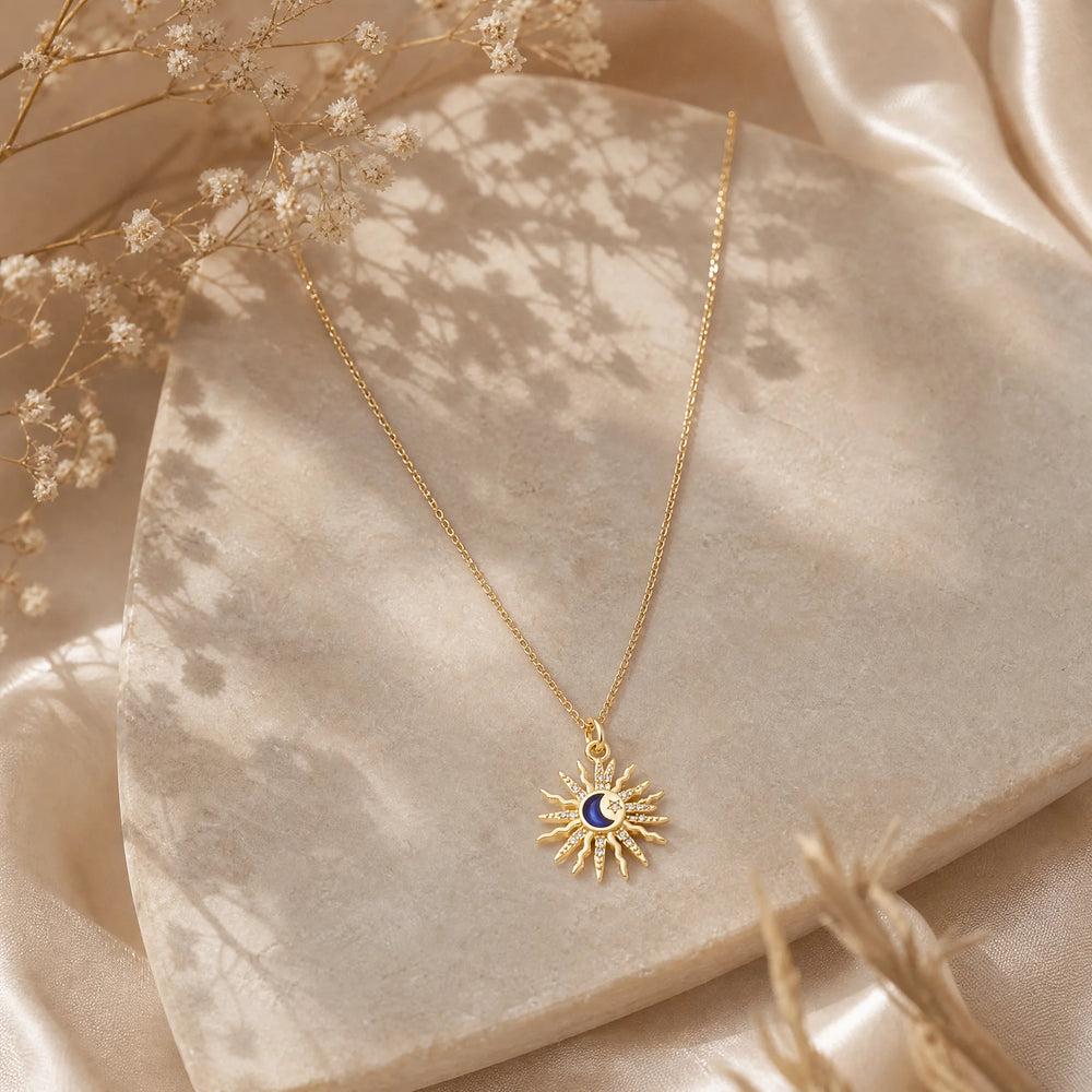 Gold sun and moon crystal pendant styled on soft satin