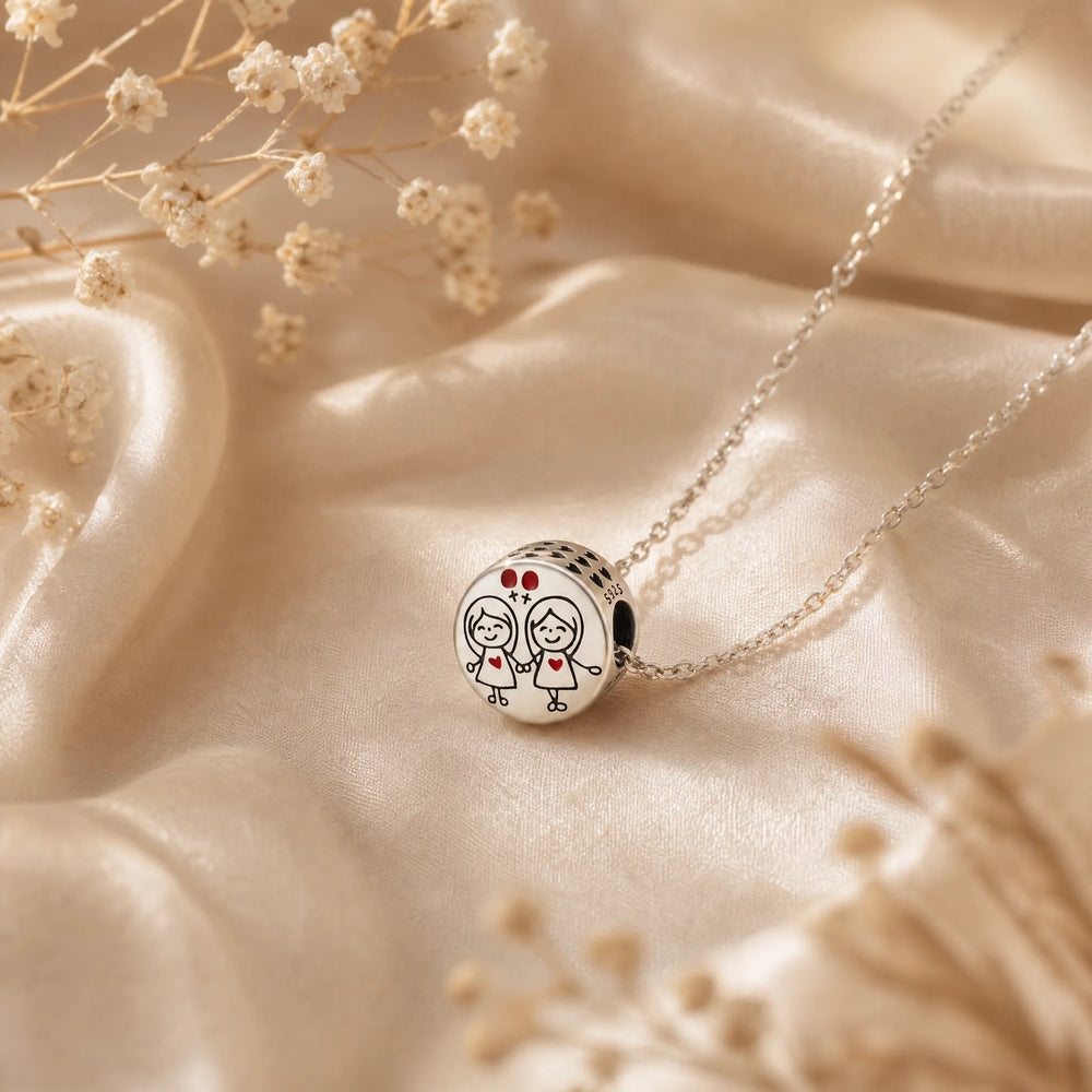 Sisters heart charm necklace styled on soft satin