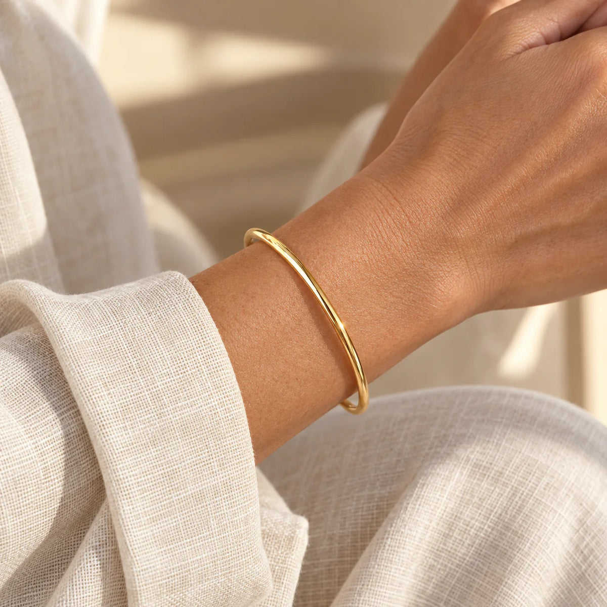 Gold Aurelia Essential Bangle worn alone on wrist
