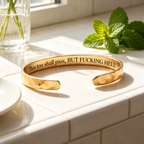 Gold hammered cuff with private engraving in a sunlit setting