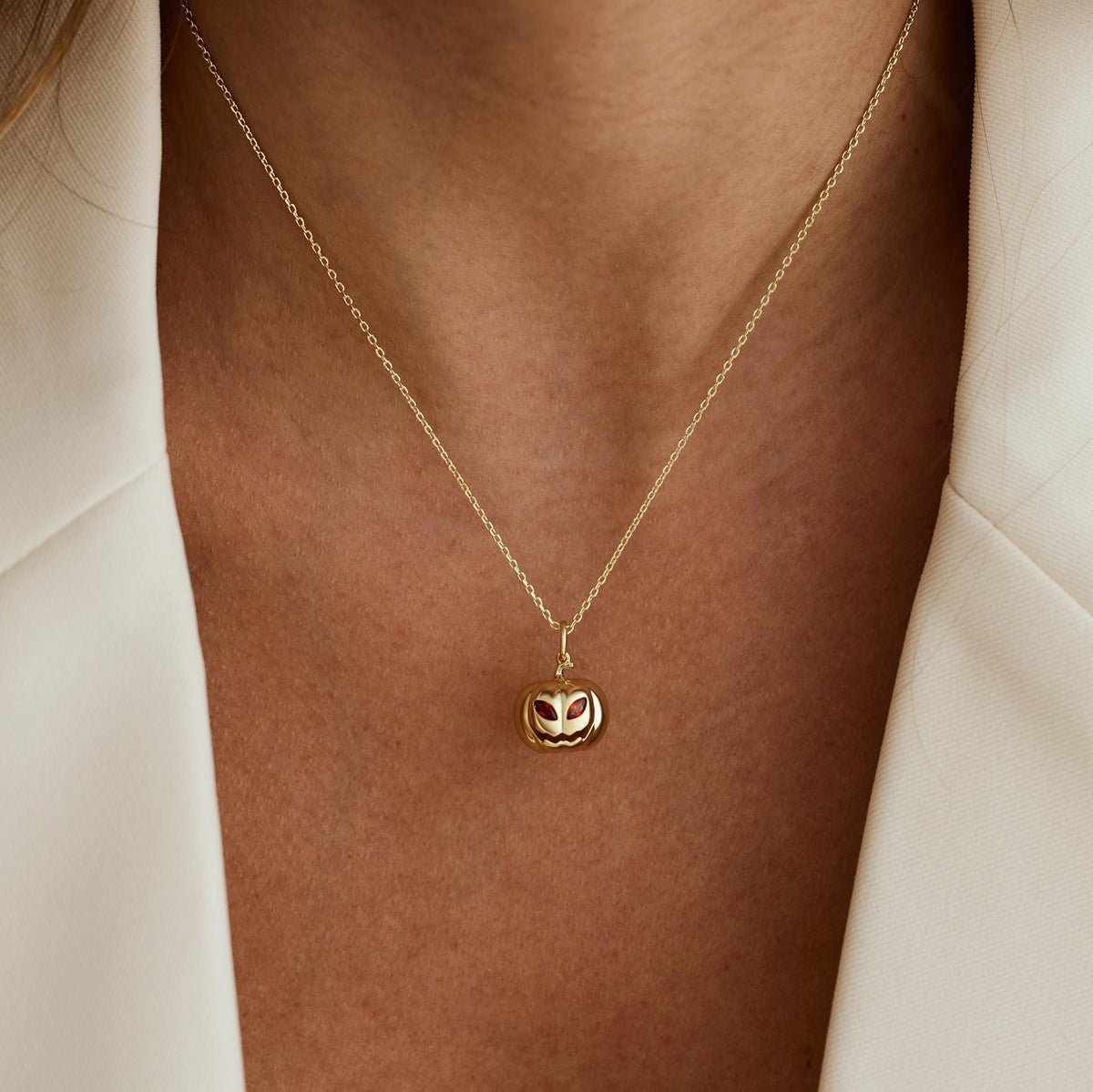 Ruby birthstone pumpkin necklace worn with a white blazer