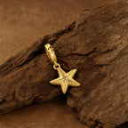 CALEO Nature & Flowers color-matched lifestyle image - Gold Starfish Dangle Charm - nature-flowers-color-gold-ref25-gold-starfish-dangle-charm - 2026-07-27