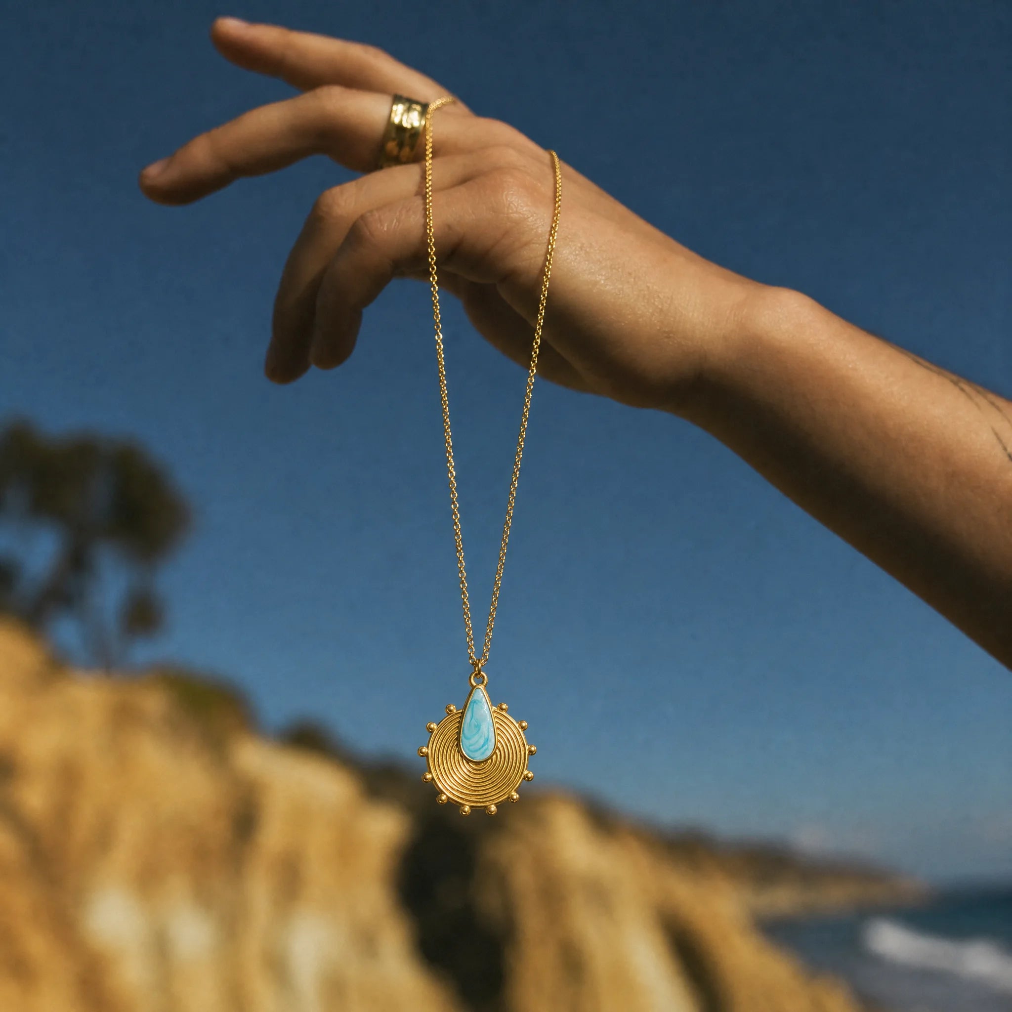 CALEO ocean lifestyle image - Gold Blue Spiral Shell Pendant Charm - ocean-ref07-gold-blue-spiral-shell-pendant-charm - 2026-07-23