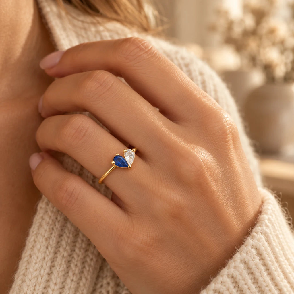 Woman wearing a gold personalised two-birthstone heart ring