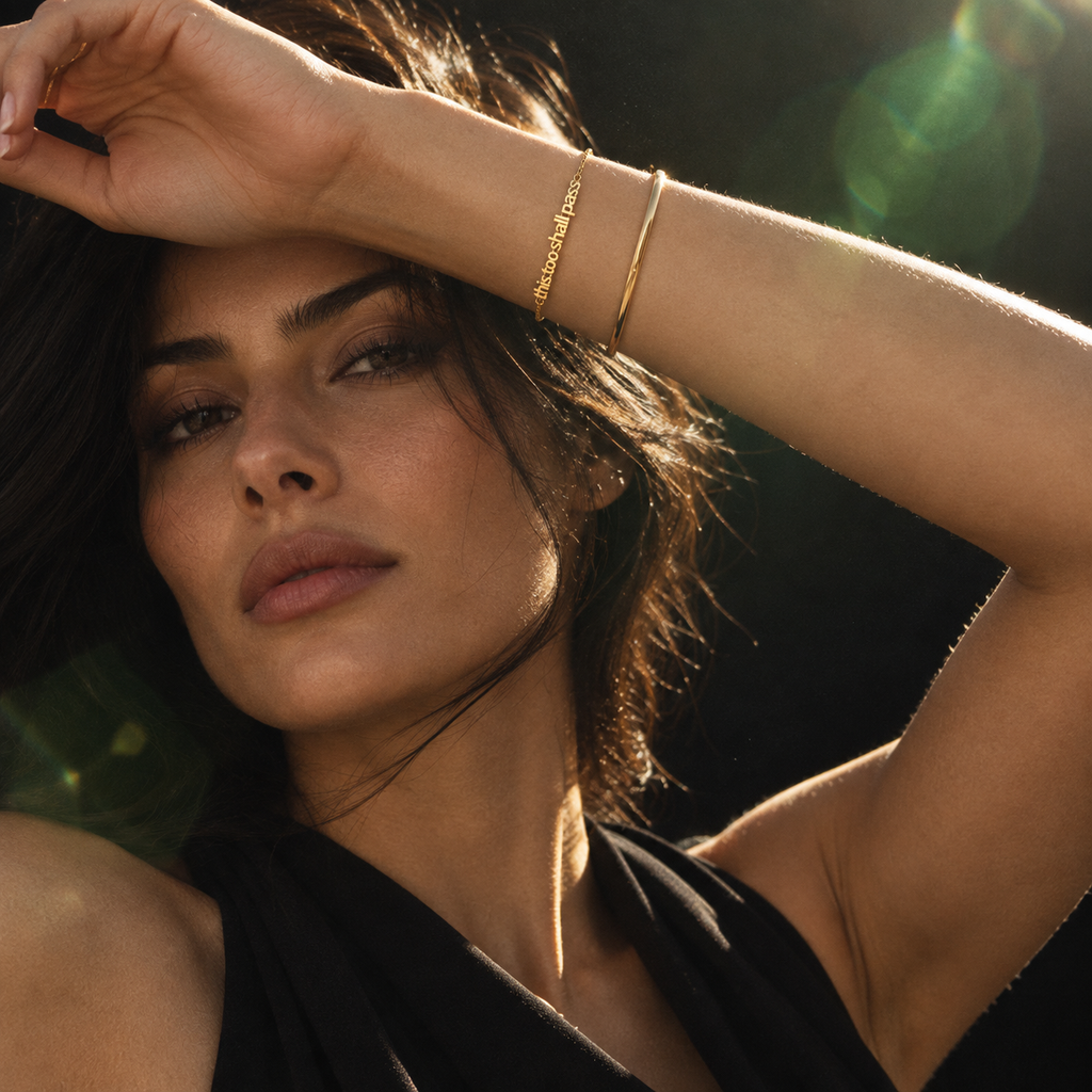 Gold This Too Shall Pass Letter Bracelet worn in a luxury editorial portrait