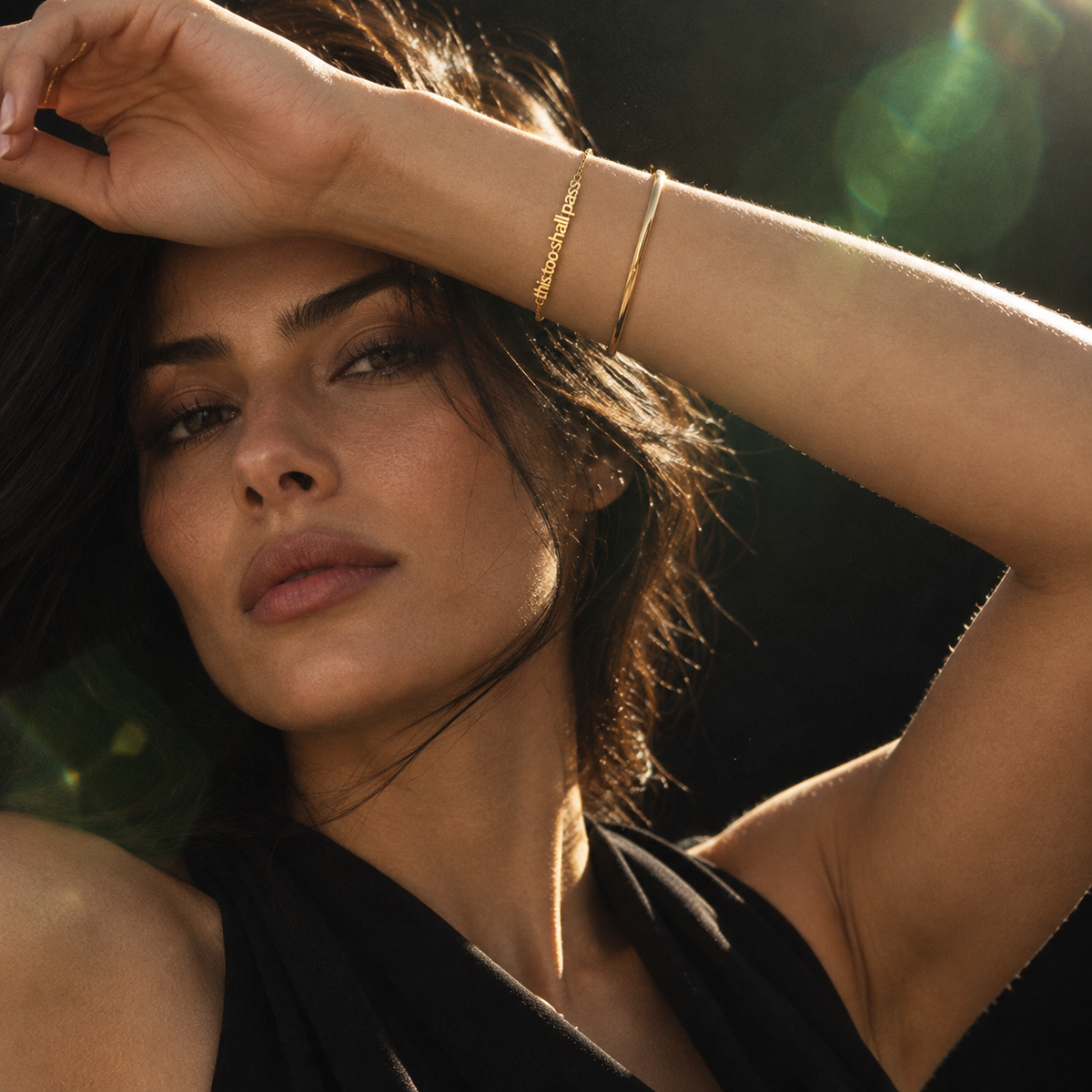 Gold This Too Shall Pass Letter Bracelet worn in a refined evening portrait