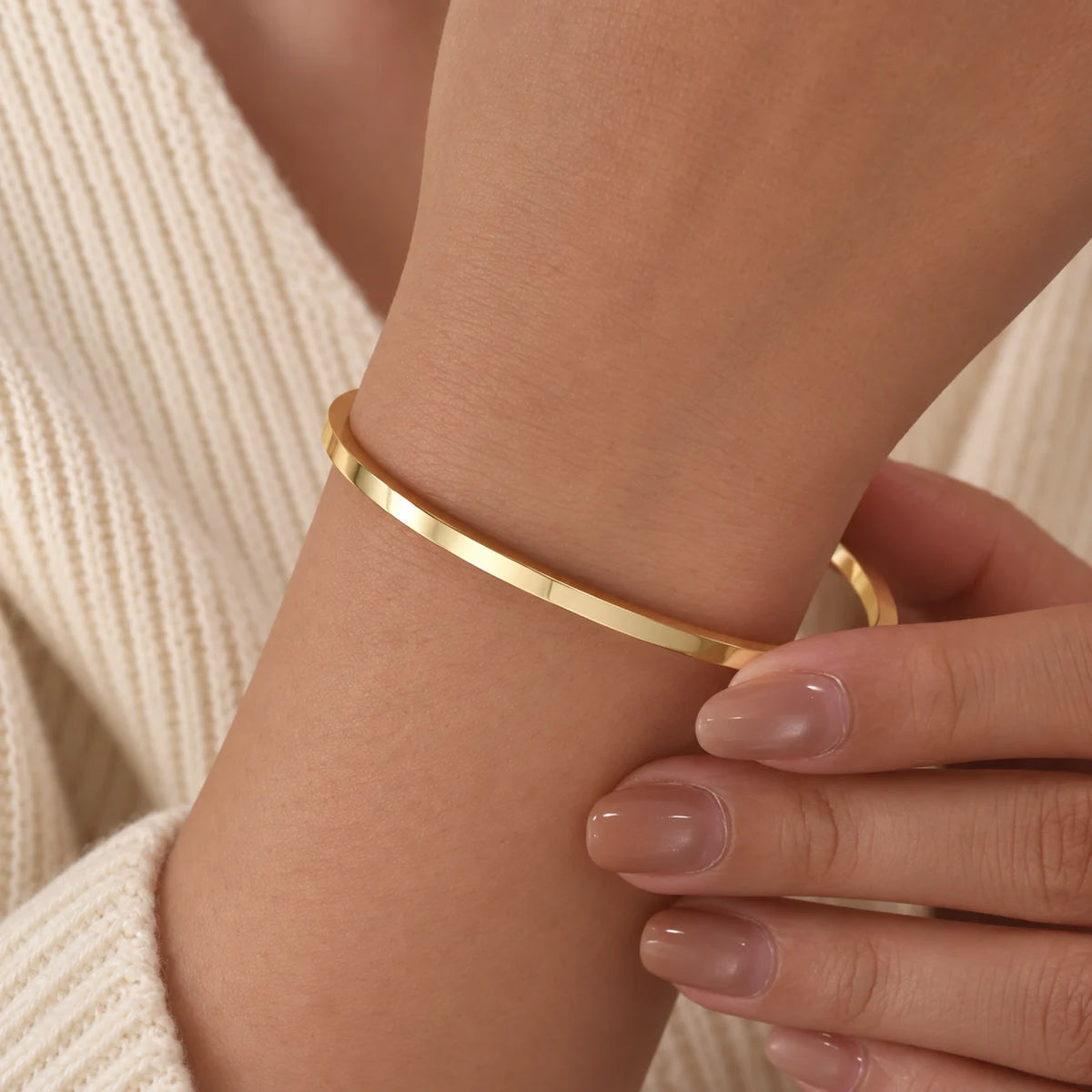 Blue enamel cuff with gold plated edges worn on the wrist