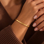 Gold This Too Shall Pass Slim Cuff with outside engraving worn on the wrist