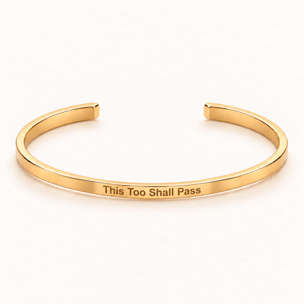 Gold open Slim Cuff with This Too Shall Pass engraved on the outside