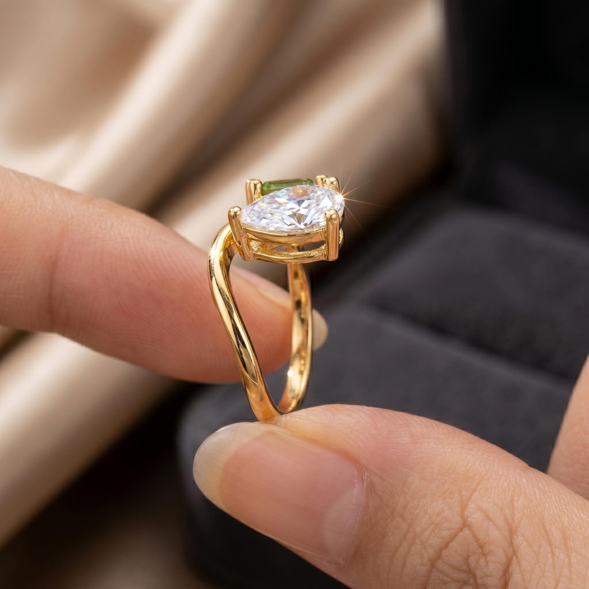 Close side view of the pear stone setting on an 18K gold plated two stone ring